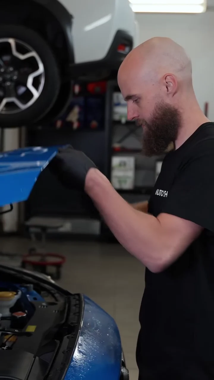 Mekaniker öppnar motorhuven i AUTO7H:s verkstad