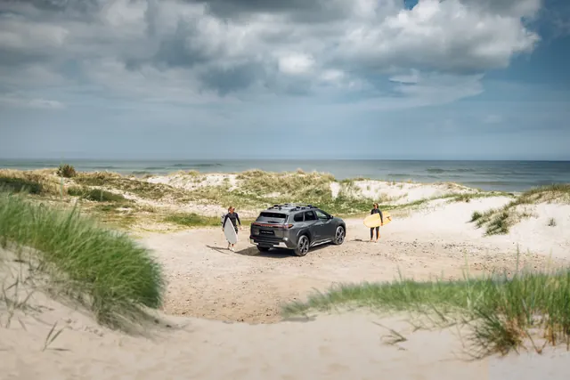 Subaru e-Outback parkerad mellan sanddyner vid havet